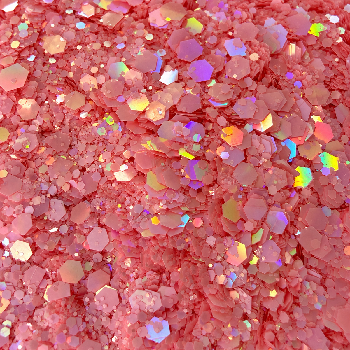 Close-up of Pink Reverie craft glitter showing blush-pink hexagons in mixed sizes with colourful iridescent reflections.