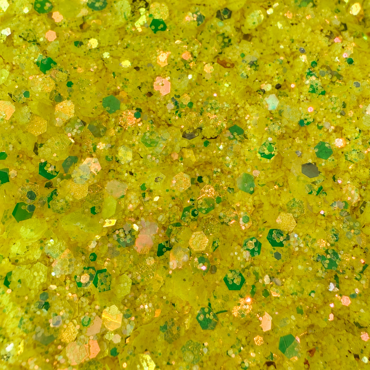 Close-up of Electric Lemonade craft glitter with yellow hexagons, fine particles and green, gold and peach reflections.