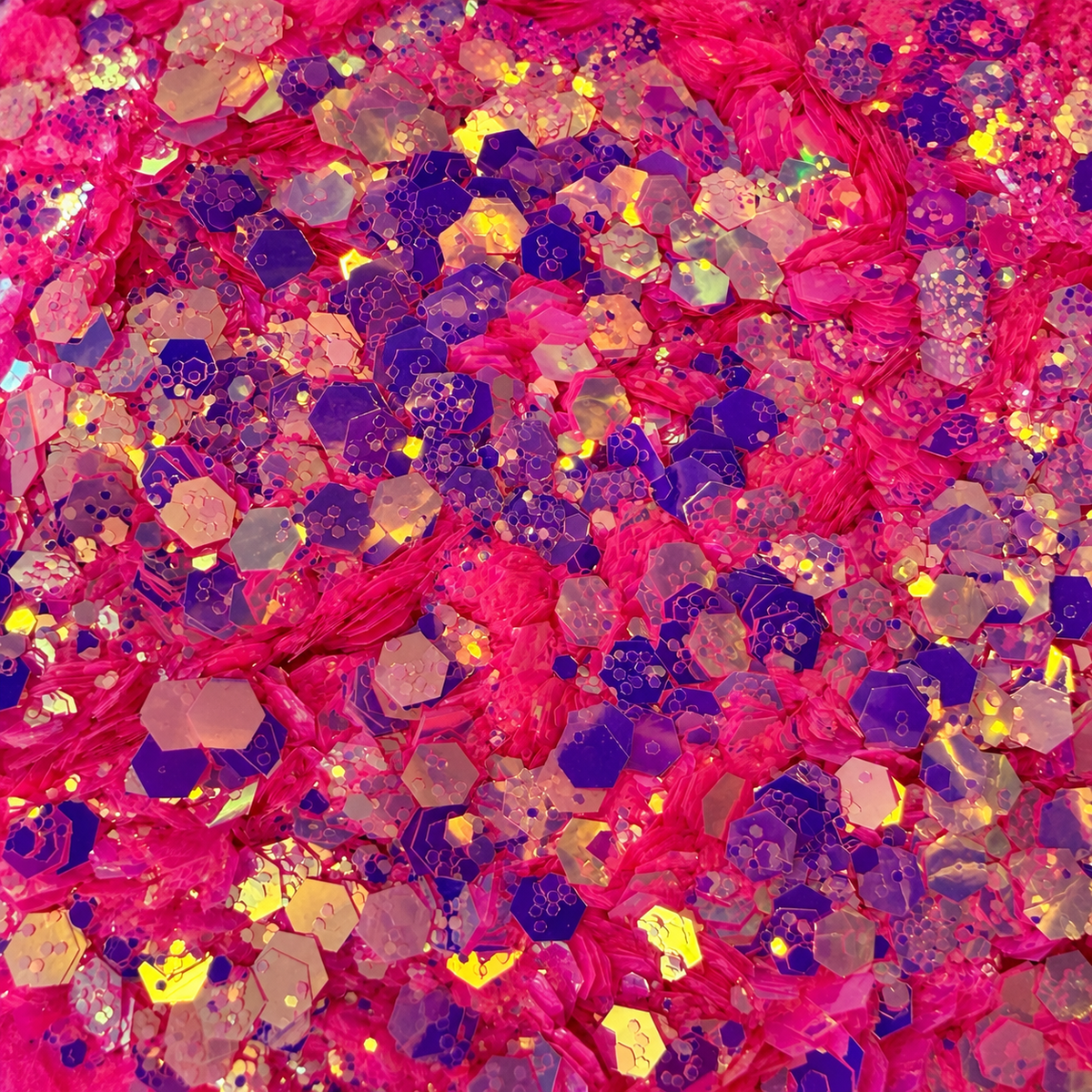 Close-up of Fuchsia Fantasy craft glitter showing bright pink hexagons with purple and golden iridescent reflections.
