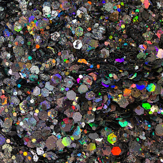 Close-up of Cosmic Noir craft glitter showing black and charcoal hexagons with colourful rainbow holographic reflections.