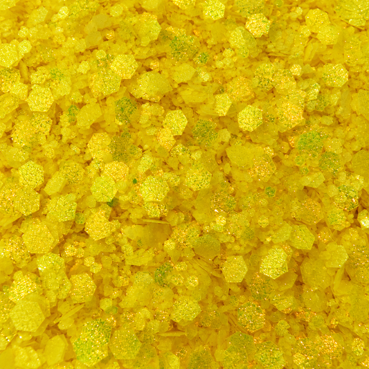 Close-up of Sunshine State craft glitter showing bright lemon-yellow hexagons in mixed sizes with fine shimmering particles.