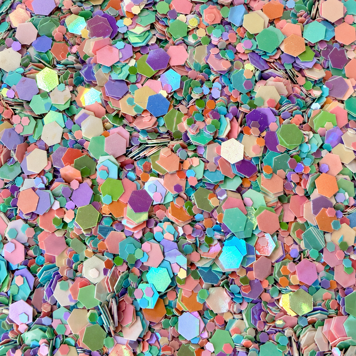 Close-up of Pastel Confetti craft glitter showing mixed-size mint, aqua, lilac, pink, peach and cream hexagons.