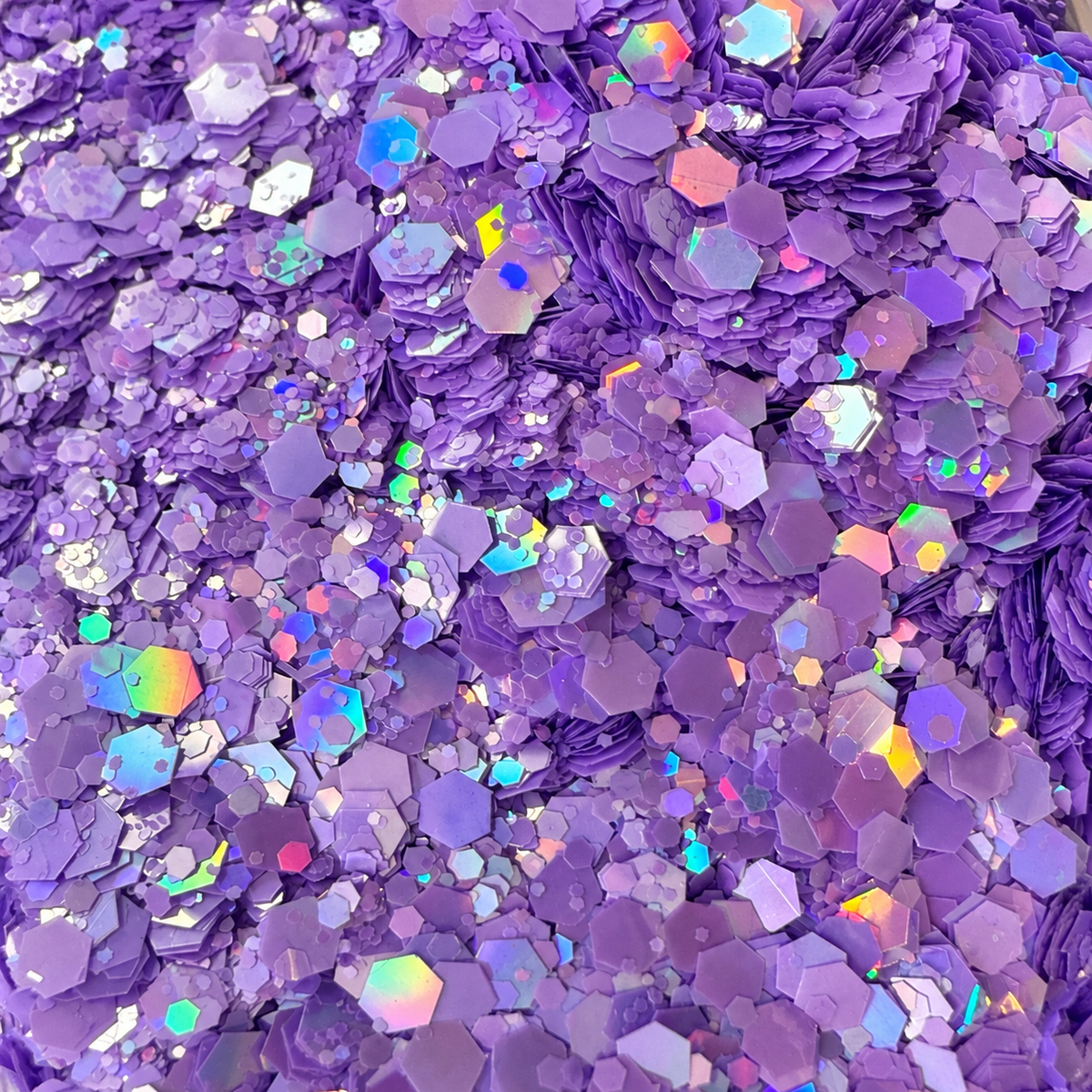 Close-up of Lilac Daydream craft glitter showing mixed-size lilac and lavender hexagons with colourful iridescent reflections.