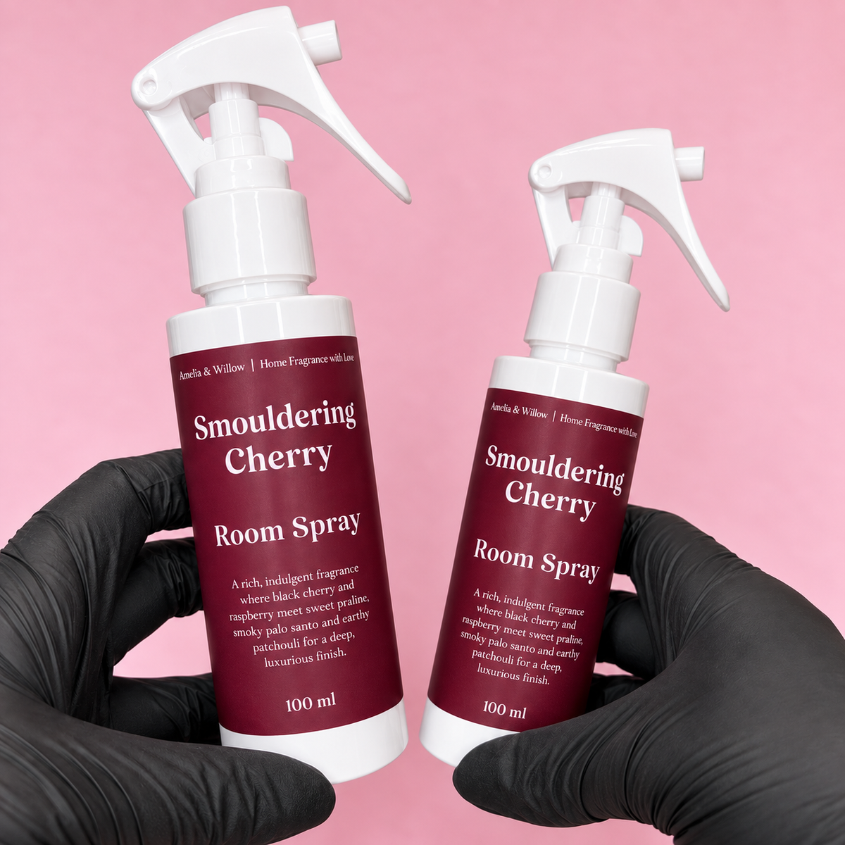 Two Smouldering Cherry Room Spray 100ml bottles by Amelia & Willow with burgundy labels on a pink background 