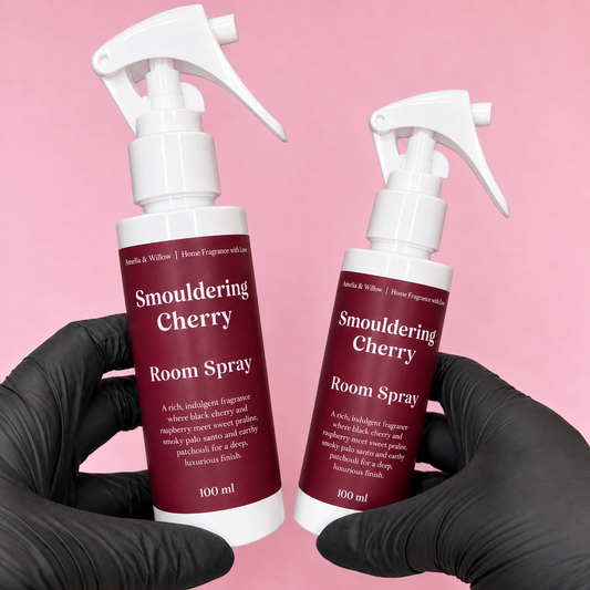 Two Smouldering Cherry Room Spray 100ml bottles by Amelia & Willow with burgundy labels on a pink background 
